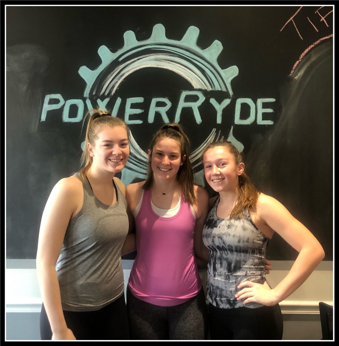 Abby Nehlen, Carlie Duesing, and Kylie Clifton in front of PoerRyde chalkboard